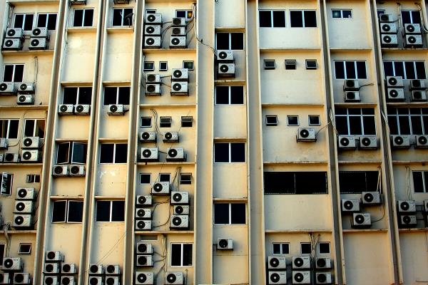 这张图片展示了城市高层建筑窗户中的空调机组。